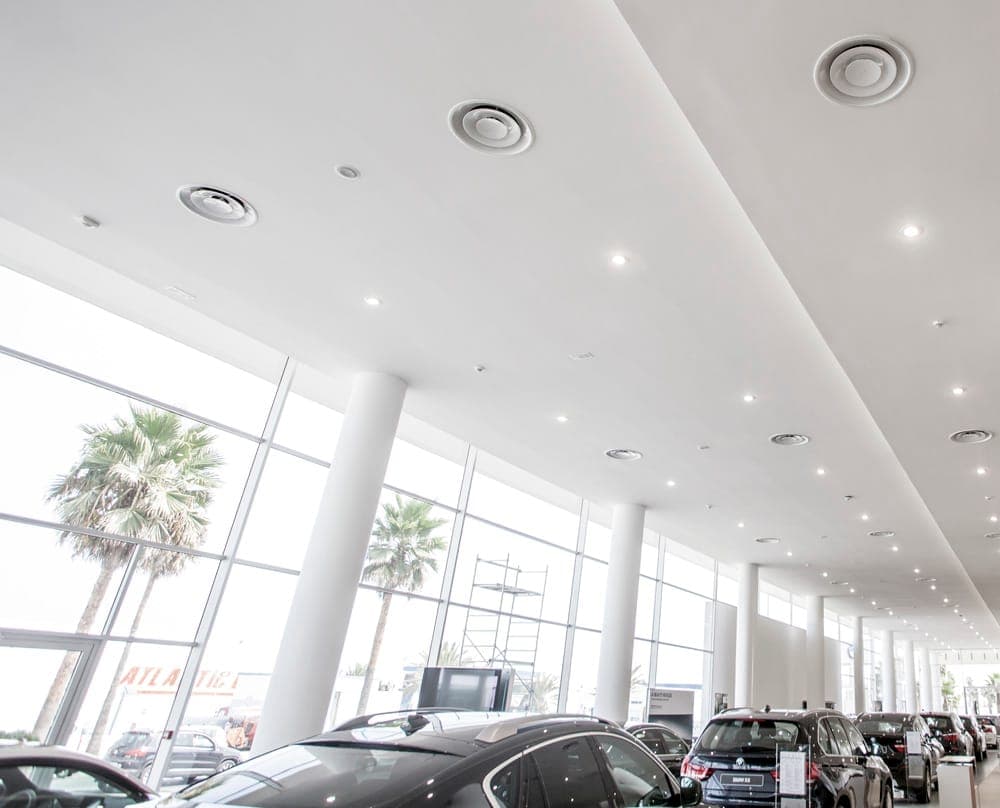 Air diffusers in a high-ceiling commercial showroom